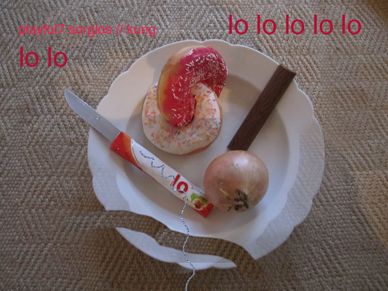 Text 'playful7 sorglos kung lo lo lo' über einem manipulierten Foto von Duplo, gleich Eheringen verschlungenen Doughnuts und einer Zwiebel