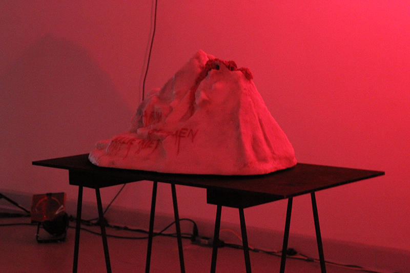 Der Vulkan-Eisberg steht in rotes Licht getaucht auf einem schwarzen Tisch
